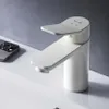A white faucet is shown on a white sink, with a gray wall in the background. A smartphone is also visible on the left side of the image. Produktbild-Vorschau