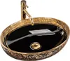 A black and gold oval countertop sink with a gold faucet. Produktbild-Vorschau