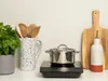 A kitchen counter with cooking equipment and a plant. Voir les images du produit