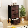 A chest of drawers with a wood-grain finish and black metal frame is shown in a room setting, next to a sofa and a potted plant. One drawer is partially open. Anteprima dell’immagine prodotto