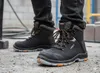 A person wearing black work boots on a construction site. Anteprima dell’immagine prodotto
