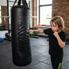 A young boy is training with a punching bag in a gym. Produktbild-Vorschau