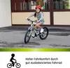 A young girl is riding a bicycle outdoors. Produktbild-Vorschau