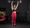 A woman is performing an overhead press with a barbell in a gym. Produktbild-Vorschau