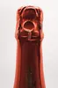 Close-up of the top of a red wine bottle, showing the foil cap and a twisted wire closure. Produktbild-Vorschau
