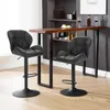 Two black bar stools are placed in front of a wooden bar counter in a room with a bookshelf in the background. Produktbild-Vorschau