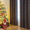 A Christmas tree decorated with lights and ornaments, next to plaid curtains and gift boxes. Produktbild-Vorschau