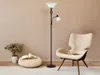 A floor lamp with a reading light is placed next to a chair in a room. Produktbild-Vorschau