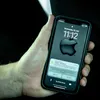 A hand holding an iPhone displaying a notification about a lost item. Voir les images du produit