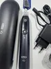 A black Oral-B iO electric toothbrush and its accessories are laid out on a white surface. Produktbild-Vorschau
