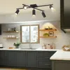 A modern kitchen with dark gray cabinets, white subway tile backsplash, and a black track light fixture. Náhled obrázku produktu