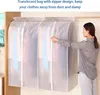 A woman zipping up a translucent garment bag hanging on a clothes rack. Náhľad obrázku produktu