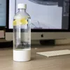 A water bottle with lemon slices sits on a desk in front of a computer monitor. Voir les images du produit