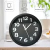 A black analog alarm clock with white numbers and hands is shown on a table. Above the clock, there are three dashed boxes with icons and text describing features: 'Big Bell Sound', 'Quieter moving hand', and 'Illumination at night'. Produktbild-Vorschau