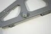 A close-up of a metal mechanism with a spring and screw attached to a gray metal plate. Produktbild-Vorschau