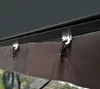 A close-up view of the top edge of a mosquito net attached to a dark gray frame with white clips. Voir les images du produit