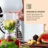 A person is using a red blender filled with ingredients to make a smoothie. The background includes a peach-colored panel with text and an icon, and a cutting board with fruit and cheese. Produktbild-Vorschau