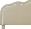 A close-up view of a beige upholstered headboard with a scalloped edge and a thin green LED light strip outlining the edge. Náhled obrázku produktu