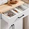 A close-up view of an open kitchen drawer with cutlery and kitchen tongs inside. Podgląd zdjęcia produktu
