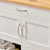 A close-up view of a white kitchen cart with a wooden countertop, showing two cabinet doors with silver handles and a drawer with a silver handle. Produktbild-Vorschau