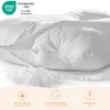 A white pillow with its filling spilling out, showing a zipper, and featuring certification and feature icons at the bottom. Produktbild-Vorschau