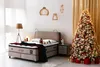 A bedroom decorated for Christmas, featuring a bed and a Christmas tree. Produktbild-Vorschau