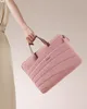 A person's hand holds a pink laptop bag. Produktbild-Vorschau