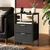 A nightstand with a turntable and drawers, next to a sofa and a plant. Náhled obrázku produktu