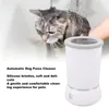 A cat is being bathed in the background, and a white automatic dog paw cleaner is in the foreground. Voir les images du produit