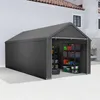 A grey storage tent is set up outdoors next to a building, with shelves and storage bins visible inside. Produktbild-Vorschau