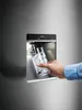 A hand is holding a water bottle under a dispenser on a refrigerator. Náhled obrázku produktu