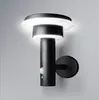 A black outdoor LED wall light with a motion sensor mounted on a light gray wall. Anteprima dell’immagine prodotto