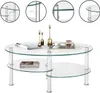 A glass coffee table with two tiers, decorated with gold candle holders and a tray with a cup and a glass. Náhľad obrázku produktu