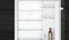 The interior of an empty refrigerator with a bottle of drink on the bottom shelf. Voir les images du produit