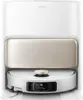 A white robot vacuum cleaner is docked in its charging station. Voir les images du produit