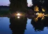 A garden pond illuminated at dusk with a spherical light. Produktbild-Vorschau