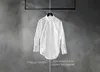 A white shirt is shown hanging on a hanger, split down the middle to show its condition after being worn for one day versus after being refreshed by a steam program. Produktbild-Vorschau