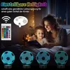 A mother and daughter are reading a book in bed, illuminated by a soccer ball-shaped night light. There are also graphics showing a remote control and light adjustment options. Produktbild-Vorschau