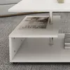 A close-up view of a white, multi-tiered coffee table with a magazine on one of its shelves. Náhled obrázku produktu
