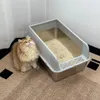 A fluffy cat sits next to an open litter box filled with litter. Produktbild-Vorschau