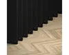 A close-up view of black lamellas and a herringbone wooden floor. Náhled obrázku produktu