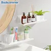 A bathroom shelf with toiletries and a plant. Voir les images du produit