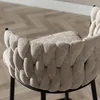 A close-up view of the back of a beige upholstered chair with a braided design. Produktbild-Vorschau