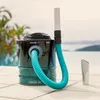 A wet vacuum cleaner is placed on a tiled surface next to a swimming pool with palm trees and a body of water in the background. Anteprima dell’immagine prodotto