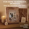 A family photo in a rustic wooden frame is displayed on a wooden surface next to a lit candle and a wrapped gift. Produktbild-Vorschau