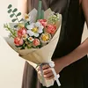 A person holding a bouquet of artificial flowers. Produktbild-Vorschau