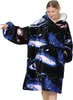 Frau trägt einen übergroßen tragbaren Decken-Hoodie mit blau-lila Galaxie-Muster, mit Kapuze und großer Vordertasche Produktbild-Vorschau
