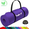 A rolled-up purple yoga mat with a black carrying strap and a logo. Several other colored mats are visible at the bottom. Podgląd zdjęcia produktu