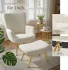 A cozy living room scene featuring a plush armchair and ottoman. Produktbild-Vorschau