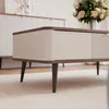 A close-up view of a modern coffee table with a drawer and ribbed detailing, set in a well-lit room. Voir les images du produit